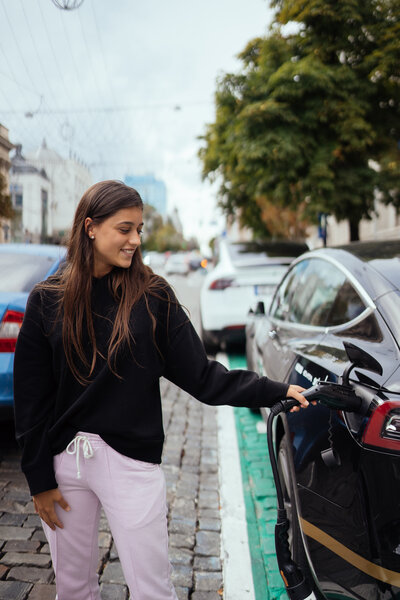 Eine Frau entscheidet sich bei der Frage Auto Abo vs. Leasing für ein E-Auto der HUK-Autowelt.